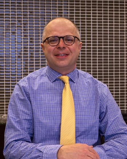 Man with blue shirt and yellow tie