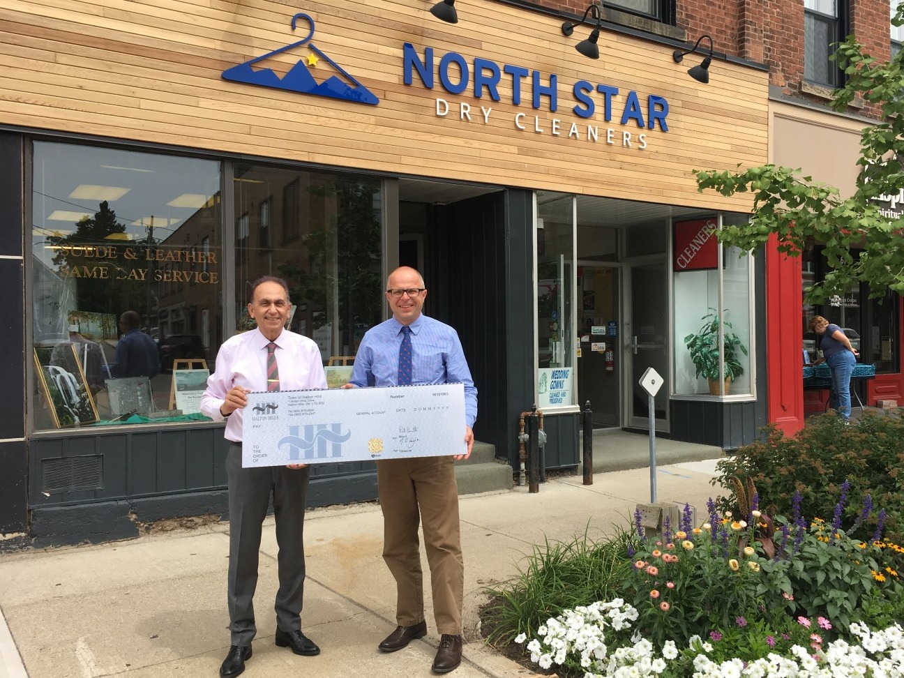 Cheque presentation in front of North Star Dry Cleaners