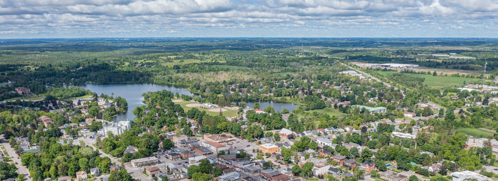 Aerial shot of Acton with lake, houses and clouds in the sky