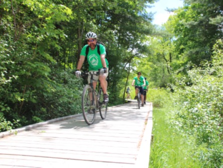 Person cycling down boardwalk